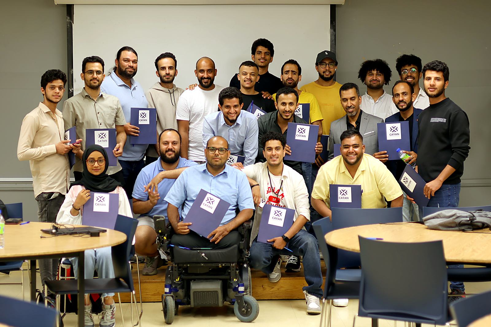 مشاركون يحملون ملفات كيان بعد لقاء مجتمعي